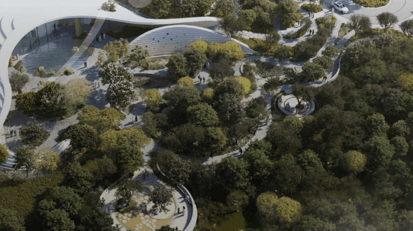 Une vue aérienne d'un parc verdoyant et luxuriant avec des sentiers sinueux, un feuillage dense et des structures architecturales modernes et incurvées. On peut voir des gens marcher le long des sentiers et se rassembler en petits groupes, créant une atmosphère animée au milieu de l'environnement naturel des bois de ghaf.