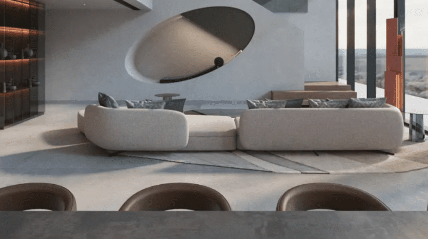 A modern living room with a large curved beige sofa facing a circular opening in the wall. The room features elegant black shelving to the left, large windows to the right offering stunning views, and a dining table in the foreground.