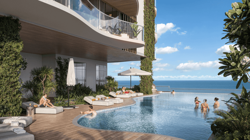 A luxurious poolside scene with an infinity pool overlooking the ocean, reminiscent of a high-end apartment in Dubai. Several people lounge on white deckchairs under umbrellas, while others enjoy the water. The modern building, adorned with greenery and a clear blue sky, creates a serene atmosphere.