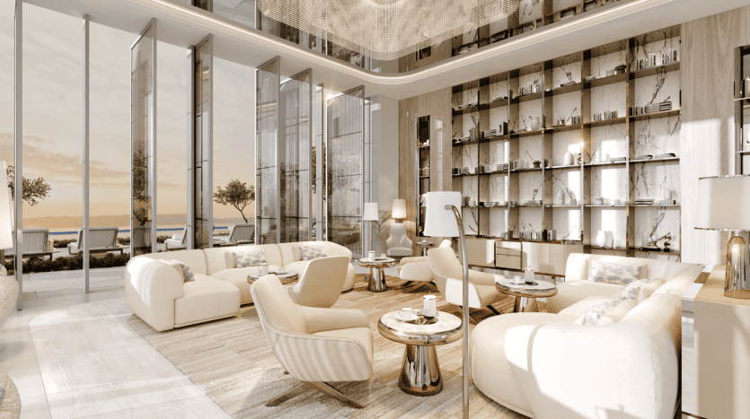 A luxurious, modern living room in the Pier with large windows offering magnificent sunset views. The room features soft beige sofas, round coffee tables and tall shelves filled with decorative objects. Natural light floods the space, underlining its elegance and sophistication.