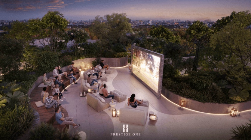 Un groupe de personnes profite d'un film dans un cinéma en plein air sur une terrasse nichée le long de la promenade, entourée d'une végétation luxuriante et illuminée par des lanternes chaleureuses. L'horizon de la ville est visible au loin sous un ciel nocturne coloré.