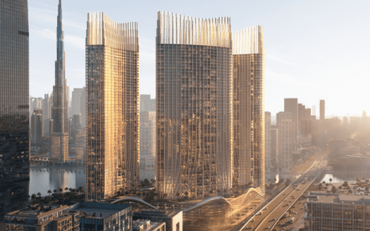 Un moderno paesaggio urbano è caratterizzato da tre eleganti grattacieli dal design architettonico unico, immersi nella luce dorata del sole. Queste imponenti strutture si affacciano su uno specchio d'acqua, mentre strade ed edifici più piccoli circondano l'area.