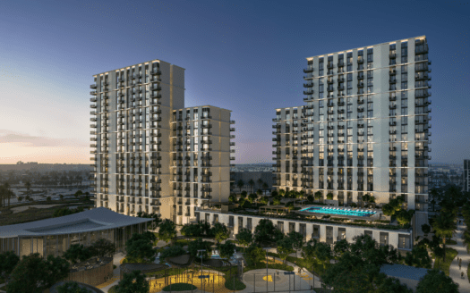 Una vista notturna del complesso di appartamenti Hillsedge rivela due alti edifici con numerosi balconi. Circondano un cortile centrale con una piscina illuminata e giardini ben curati, mentre il cielo passa elegantemente dal tramonto all'alba.