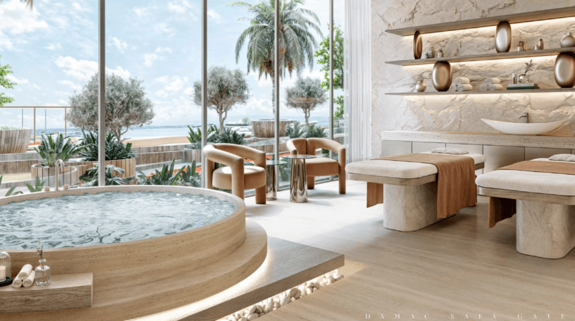 Une luxueuse salle de spa avec deux tables de massage, un jacuzzi rond et un coin salon. De grandes fenêtres révèlent une vue extérieure ensoleillée avec des palmiers et des aperçus de la mer depuis le prestigieux Safa Gate Damac. Des étagères présentent des objets décoratifs, renforçant l'atmosphère sereine.