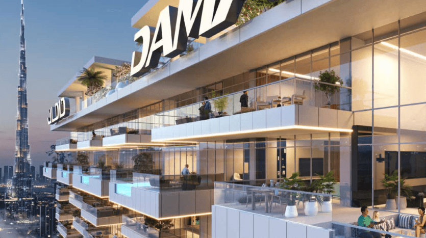 Immeuble de luxe de grande hauteur avec terrasses distinctes ornées de plantes et de coins salon, arborant fièrement un grand panneau « Damac ». La Burj Khalifa au loin orne le ciel crépusculaire, offrant une vue imprenable depuis la porte de Safa.