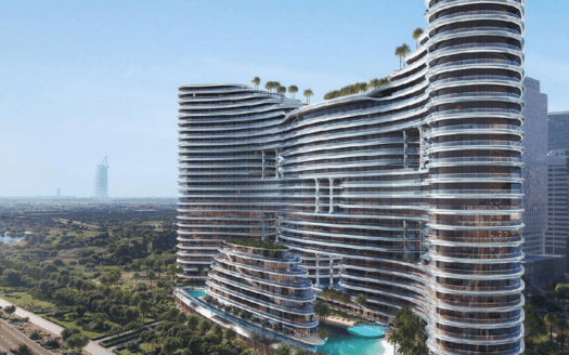 Un grattacielo moderno e curvo, il Binghatti Aquarise, con facciate in vetro e tetti verdi, si erge accanto a una piscina, circondato da un paesaggio lussureggiante, con una lontana torre di riferimento visibile contro il cielo blu.