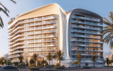 Un immeuble d'appartements moderne à plusieurs étages, aux lignes architecturales courbes et épurées et doté de grands balcons, entouré de palmiers et éclairé par la chaleur du soleil, se dresse à côté d'une rue avec des voitures garées.