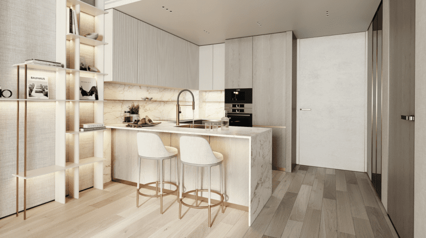 Cuisine moderne minimaliste avec sol en bois clair, comptoirs en marbre, deux tabourets de bar blancs, appareils électroménagers intégrés, étagères ouvertes avec livres et objets de décoration, et éclairage d'ambiance doux. Palette de couleurs neutres avec des tons beiges et blancs.