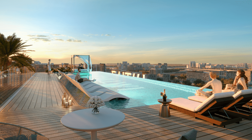 Alors que le soleil se couche sur la ville, les clients du Cove Edition 6 de Imtiaz se détendent au bord de la piscine à débordement située sur le toit. Des palmiers, des bougies et une table garnie de fleurs et de champagne créent une ambiance propice à la détente.