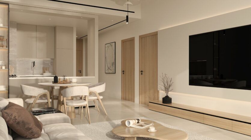 Salon et salle à manger modernes et minimalistes à Ayaan Heights 1 par IGO, avec des tons beiges et neutres, des meubles en bois clair, une table à manger ronde avec quatre chaises, une télévision murale, une table basse sur un tapis, et une cuisine visible à l'arrière-plan.