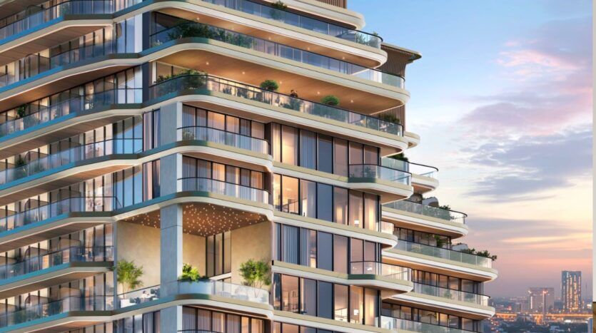 Le Marquis One Arjan, immeuble d'appartements moderne de plusieurs étages, présente des balcons en verre incurvé, des plantes vertes luxuriantes et un éclairage chaleureux au coucher du soleil, avec vue sur un paysage urbain époustouflant et des gratte-ciel éloignés.
