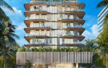 Immeuble moderne de plusieurs étages avec balcons incurvés et garde-corps en verre, entouré de palmiers. Avida Residences Dubai Islands présente de la verdure sur chaque balcon et un design épuré et contemporain sur fond de ciel bleu vif.