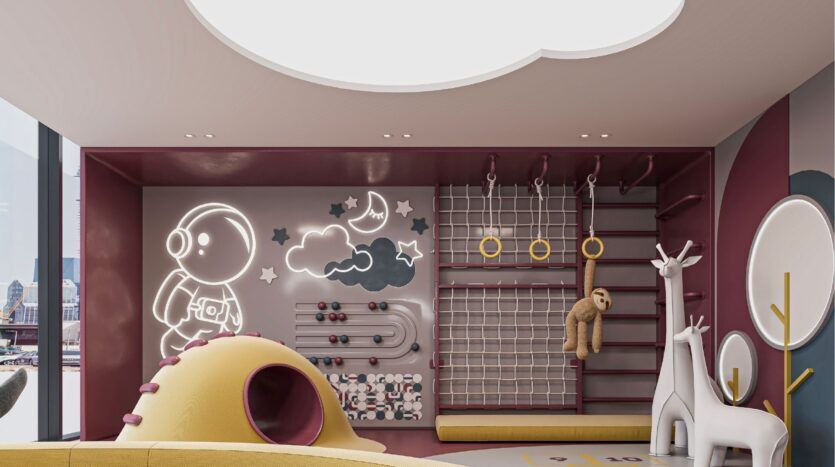 A modern indoor playroom with a climbing wall, rope net, gymnastic rings, yellow tunnel and white giraffe statues. Playful details like an abacus and a luminous astronaut evoke the fun style of Sierra by Iman. Large windows bring in natural light.