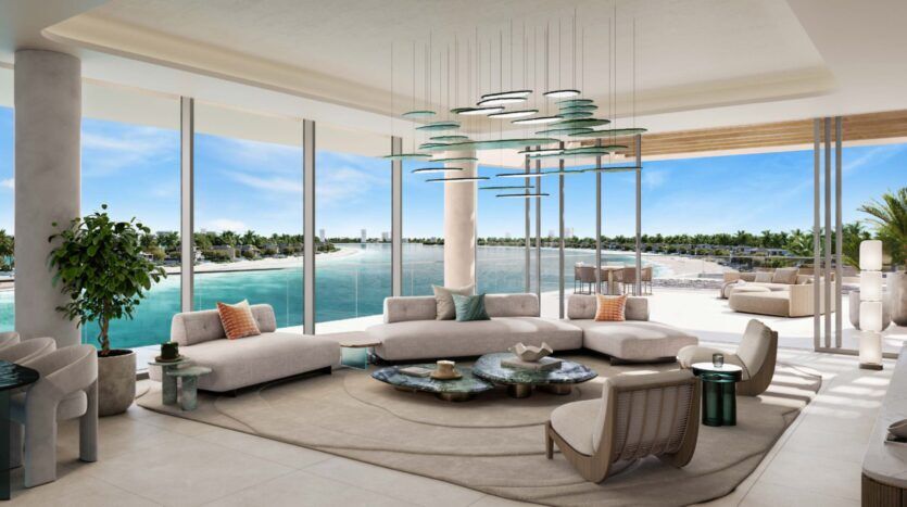 This modern, spacious Palm Central lounge features large windows offering panoramic views of the turquoise waterfront and palm trees. The room features neutral-toned furnishings, elegant decor and plenty of natural light.