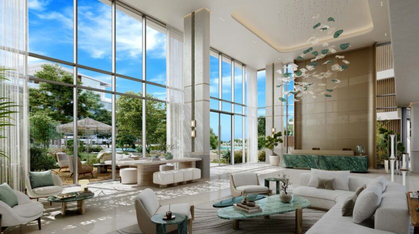 Spacious, modern Palm Central living room with high ceilings, floor-to-ceiling windows, elegant white furnishings, marble accents, decorative chandelier, lush plants and a view of a sunny outdoor garden and blue sky.