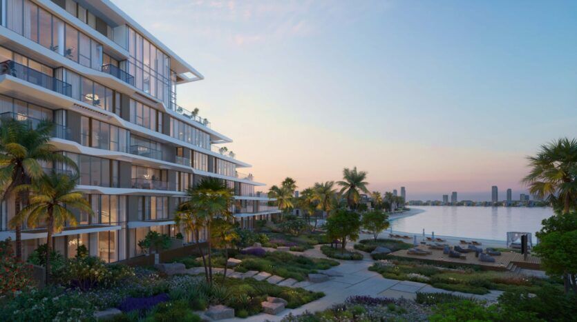 Palm Central's modern beachfront apartments feature large windows overlooking landscaped gardens, palm trees and waterside lounging areas at sunset, with breathtaking views of the city across the bay.