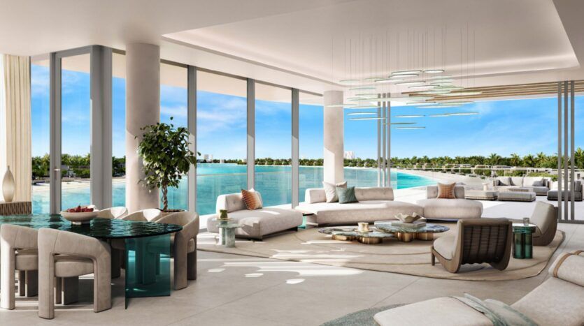Spacious, modern Palm Central lounge with large windows overlooking a blue pool and palm trees. The elegant furniture, round table and contemporary chandelier create a luxurious, open and serene atmosphere.