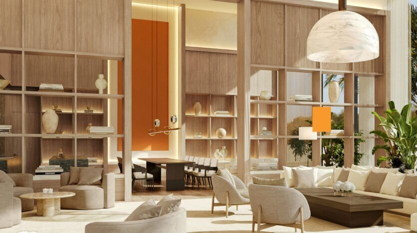 Salon moderne et ensoleillé de l'Edition avec des canapés crème, des tables rondes et des étagères en bois ouvertes présentant des vases et des livres. Une salle à manger est visible à l'arrière-plan, séparée par de hautes étagères. Une grande lampe suspendue est accrochée au-dessus.