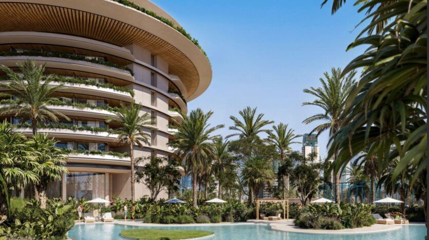 Le luxueux bâtiment incurvé de l'Edition, doté de balcons, donne sur une piscine tropicale encadrée de palmiers, d'une végétation luxuriante et de chaises longues ombragées par des parasols blancs lors des journées ensoleillées.