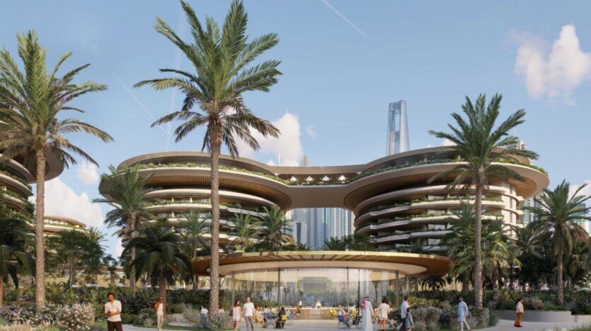 Bâtiment moderne et futuriste aux arêtes incurvées et aux jardins luxuriants, The Edition est entouré de palmiers. Des gens se promènent et s'assoient à des tables en plein air au premier plan, tandis que de grands gratte-ciel s'élèvent à l'arrière-plan sous un ciel bleu.