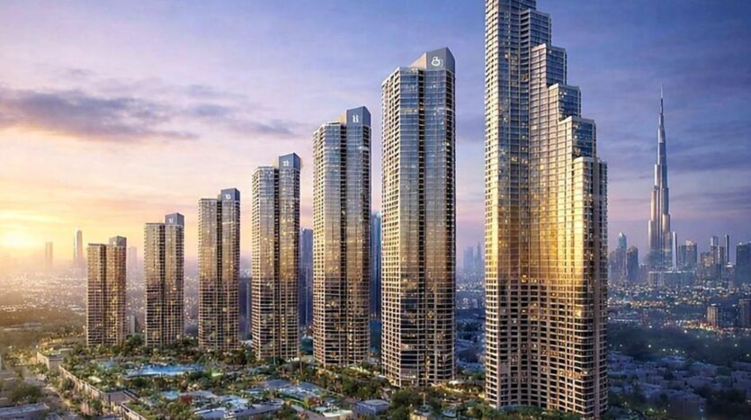 Eine Reihe hoher, moderner Wolkenkratzer mit Glasfassaden reflektiert das Licht der untergehenden Sonne im Herzen von Mercedes Benz City. Die Skyline besteht aus Hochhäusern, mit dem ikonischen Burj Khalifa im Hintergrund und Grünflächen darunter.