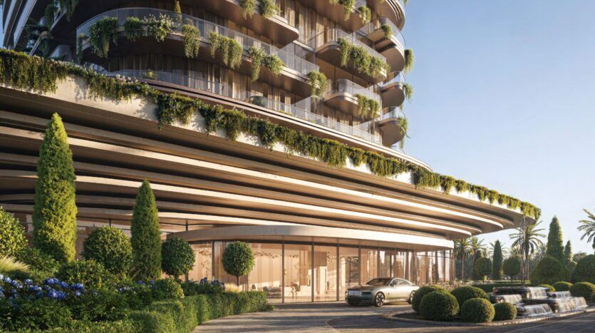 A modern building called Le Château with curved balconies covered in greenery, large bay windows, landscaped shrubs, a car parked at the entrance, with a fountain and palm trees in the background.