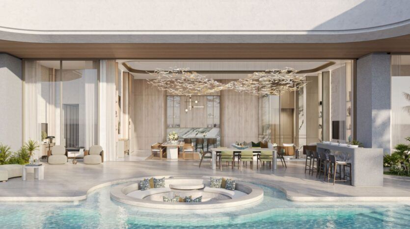 Espace de vie moderne et ouvert des résidences Amali, avec de grandes portes vitrées qui s'ouvrent sur un salon circulaire en contrebas entouré d'une piscine ; décor élégant, tons neutres et mobilier contemporain.