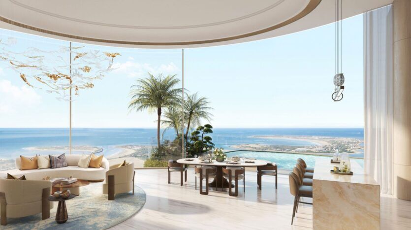 Salon et salle à manger spacieux et modernes des résidences Amali, avec de grandes fenêtres incurvées allant du sol au plafond et offrant une vue panoramique sur l'océan, le ciel bleu, les palmiers et le littoral sablonneux ; mobilier de couleur claire et décor minimaliste.