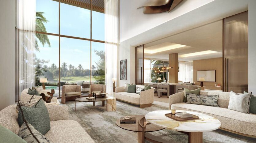 Salon spacieux et moderne des résidences privées Four Seasons, avec de grandes fenêtres allant du sol au plafond, des canapés aux tons neutres, une table basse en marbre et de la verdure à l'extérieur. L'agencement ouvert mène à une salle à manger bien éclairée au décor contemporain.
