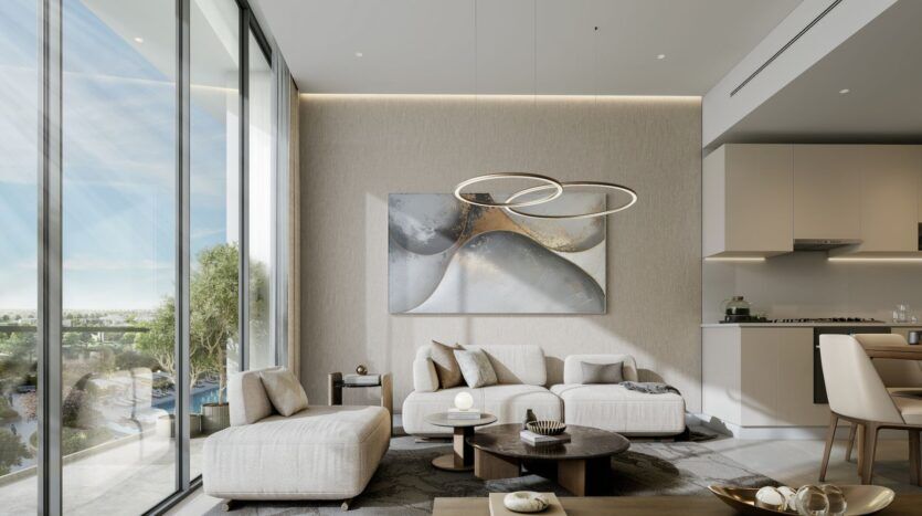 Salon moderne de River Cove Residences avec des fenêtres allant du sol au plafond, des canapés beige clair, une table basse ronde, des œuvres d'art murales abstraites et un lustre contemporain en forme d'anneau. La verdure extérieure est visible à travers les vitres ; la cuisine est partiellement visible à droite.