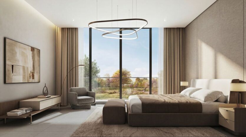 Chambre à coucher moderne à The Terraces by Sobha avec un grand lit, des tons neutres, des luminaires élégants, un fauteuil, des œuvres d'art au mur et de grandes fenêtres allant du sol au plafond offrant des vues lumineuses sur les arbres et le paysage naturel.