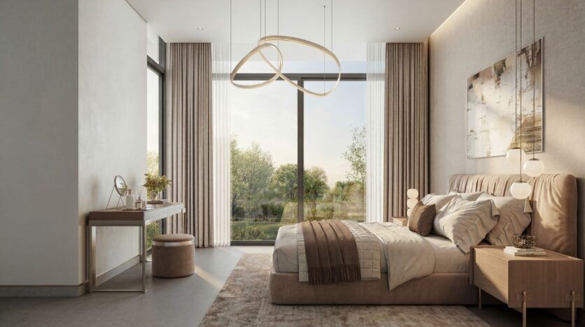 La chambre à coucher moderne de The Terraces by Sobha se caractérise par une grande fenêtre, des murs beiges, un lit double avec des oreillers et une couverture, deux tables de nuit avec des lampes, un meuble-lavabo avec un tabouret, et une lumière naturelle douce qui remplit la pièce.