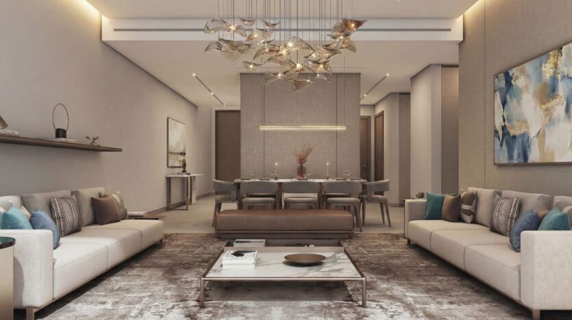 Élégant salon moderne à The Terraces by Sobha avec des tons neutres, deux canapés beiges, une table basse en marbre, un lustre abstrait, un grand tapis, des œuvres d'art murales et un coin salle à manger. Un éclairage doux et chaud crée une atmosphère chaleureuse.