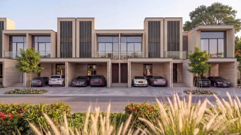 Rangée moderne de maisons de ville à deux étages à The Terraces by Sobha, avec de grandes fenêtres et des allées couvertes avec des voitures garées. Un aménagement paysager luxuriant, des arbres, de l'herbe et des fleurs éclatantes rehaussent l'aspect pittoresque de l'avant-plan.