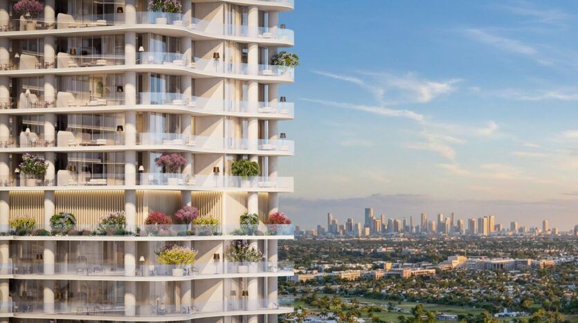 The Wow Tower, a modern skyscraper with balconies adorned with lush greenery, overlooks the cityscape and the distant skyline beneath a blue sky dotted with scattered clouds.
