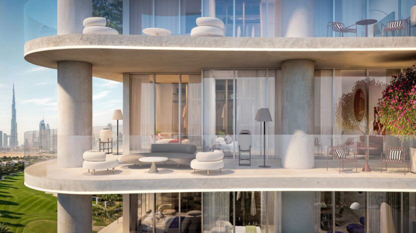 The balcony of a modern apartment in the Wow Tower features curved glass railings, contemporary outdoor furniture, potted plants, and views of the city, including the Burj Khalifa. Large windows offer a glimpse into the elegant interior living space.