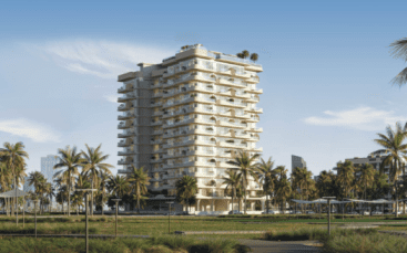 Cybele by Wadan est un immeuble d'appartements moderne de plusieurs étages, doté de nombreux balcons et entouré de palmiers et de verdure, sous un ciel bleu clair en milieu urbain.