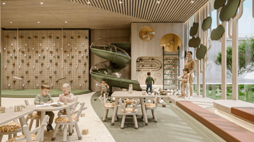 Une salle de jeux intérieure moderne présentant Cybele de Wadan, avec de jeunes enfants jouant à des tables, un mur d'escalade, un toboggan à double spirale, une fosse à balles, des accents en bois et une décoration murale en forme d'arbre. Espace lumineux avec de grandes fenêtres et un adulte superviseur.