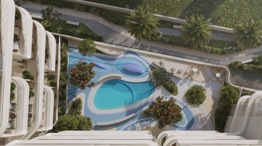 Vue aérienne d'une piscine moderne de forme organique aux lignes courbes, entourée de chaises longues, de palmiers et d'une végétation luxuriante - une oasis extérieure accueillante rehaussée par le design élégant de Cybele by Wadan.