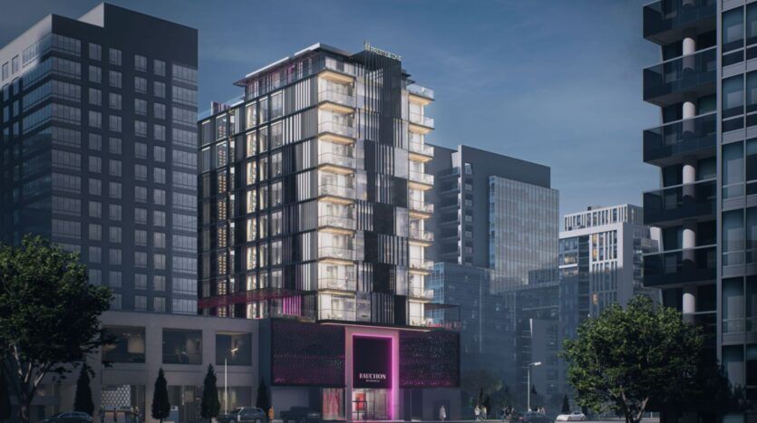 Un hôtel moderne de plusieurs étages, la résidence Fauchon, avec des balcons en verre et des enseignes lumineuses, se trouve dans une zone urbaine entourée d'immeubles de grande hauteur, avec des arbres et des personnes visibles au niveau de la rue.