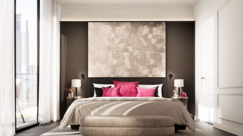 Une chambre moderne de la résidence Fauchon avec un grand lit, des oreillers blancs et roses, une literie beige, deux tables de chevet avec lampes, un tableau mural géométrique au-dessus de la tête de lit et des fenêtres allant du sol au plafond pour laisser entrer la lumière naturelle.