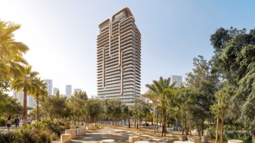 Une tour moderne, Rotana Residences, à l'architecture unique et sinueuse, se dresse derrière un parc rempli de palmiers et de bancs circulaires en pierre lors d'une journée ensoleillée.