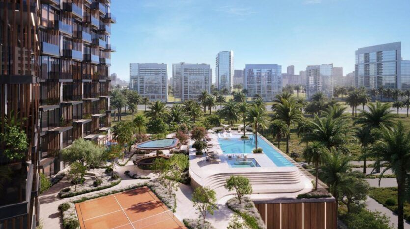 Un complexe d'appartements moderne à Winslow comprend une piscine, des chaises longues et des jardins paysagers donnant sur des palmiers et des courts de tennis, avec de nombreux grands bâtiments en verre en arrière-plan sous un ciel bleu clair.