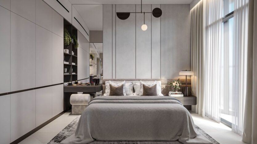 Chambre à coucher moderne et minimaliste avec un grand lit, des tons gris neutres, de hautes fenêtres avec des rideaux transparents, des étagères encastrées, des plantes décoratives et des luminaires Tresora by Wadan au-dessus de la tête de lit.