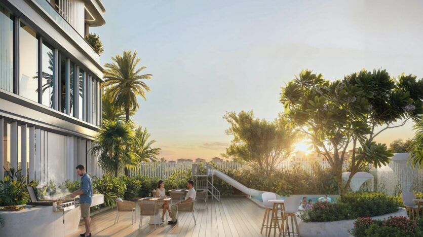 Les gens dînent et se détendent sur le toit-terrasse moderne de Tresora by Wadan, entouré de verdure luxuriante et de palmiers au coucher du soleil. Une personne fait griller des aliments tandis que d'autres s'assoient à des tables, profitant de l'atmosphère vibrante de l'extérieur.