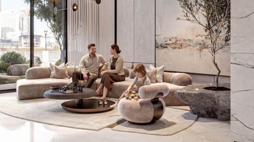Un salon moderne avec un homme et une femme assis sur un canapé beige, discutant, tandis qu'un enfant joue avec des cubes en bois sur une chaise ronde. De grandes fenêtres et des œuvres d'art créent l'ambiance lumineuse et élégante de Tresora by Wadan.