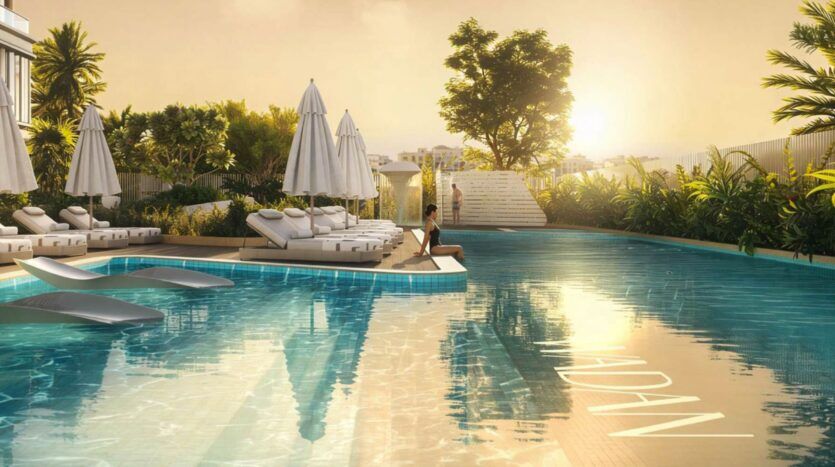 La piscine extérieure de Tresora by Wadan est entourée de chaises longues et de parasols, d'une végétation luxuriante et d'une personne assise au bord de la piscine. La lumière dorée du soleil baigne la scène, créant une atmosphère relaxante.