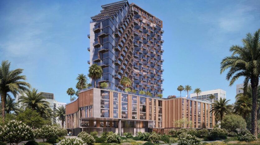 Immeuble moderne de grande hauteur avec une façade géométrique unique, l'élégance de Winslow brille au milieu des palmiers et d'un paysage luxuriant, avec pour toile de fond un ciel bleu clair dans un environnement urbain.