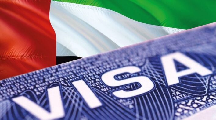 Gros plan sur un visa d'investisseur américain superposé au drapeau partiellement visible des Émirats arabes unis en arrière-plan.