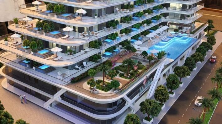Maquette d'un appartement moderne à plusieurs niveaux à Dubaï avec terrasses paysagées, piscines, entourées d'arbres et de petites figures représentant des personnes et des voitures.